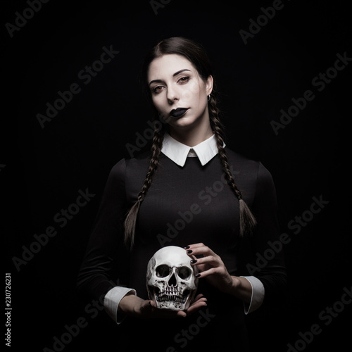 Young woman with pale skin with skull, gothic theme, mysteryous atmosphere