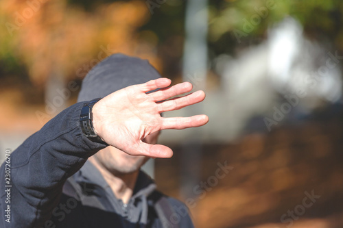 man hides his face with his hand © Sergey