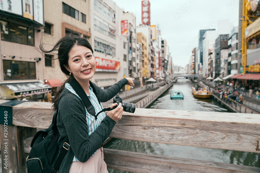 asian girl pointing at the boat on the canal