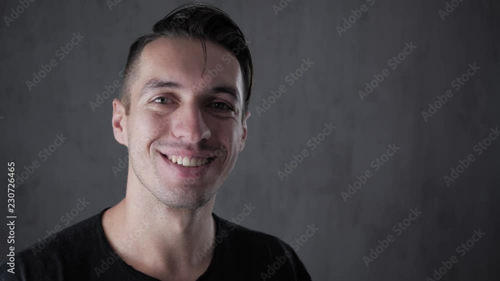 Closeup portrait of young stylish man at gray background Closeup portrait of young stylish man at gray background