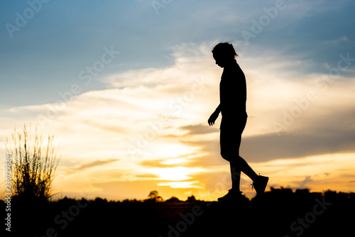 Fototapeta Naklejka Na Ścianę i Meble -  silhouette woman running alone at beautiful sunset in the park.