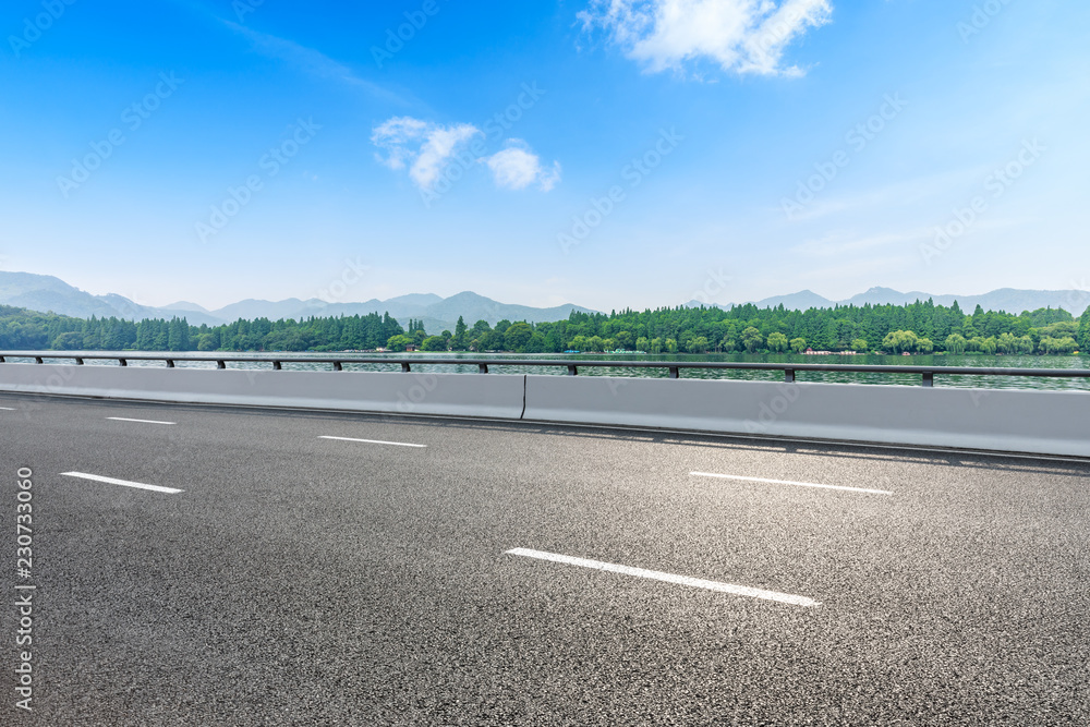 Fototapeta premium Asphalt road and beautiful mountain under the blue sky
