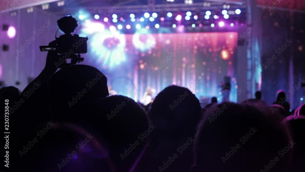 Crowd people at music concert . Cheering crowd in front of bright colorful stage lights. silhouettes of concert crowd in front of bright lifestyle stage lights. crowd of people at a concert concept Crowd people at music concert . Cheering crowd in front of bright colorful stage lights. silhouettes of concert crowd in front of bright lifestyle stage lights. crowd of people at a concert concept