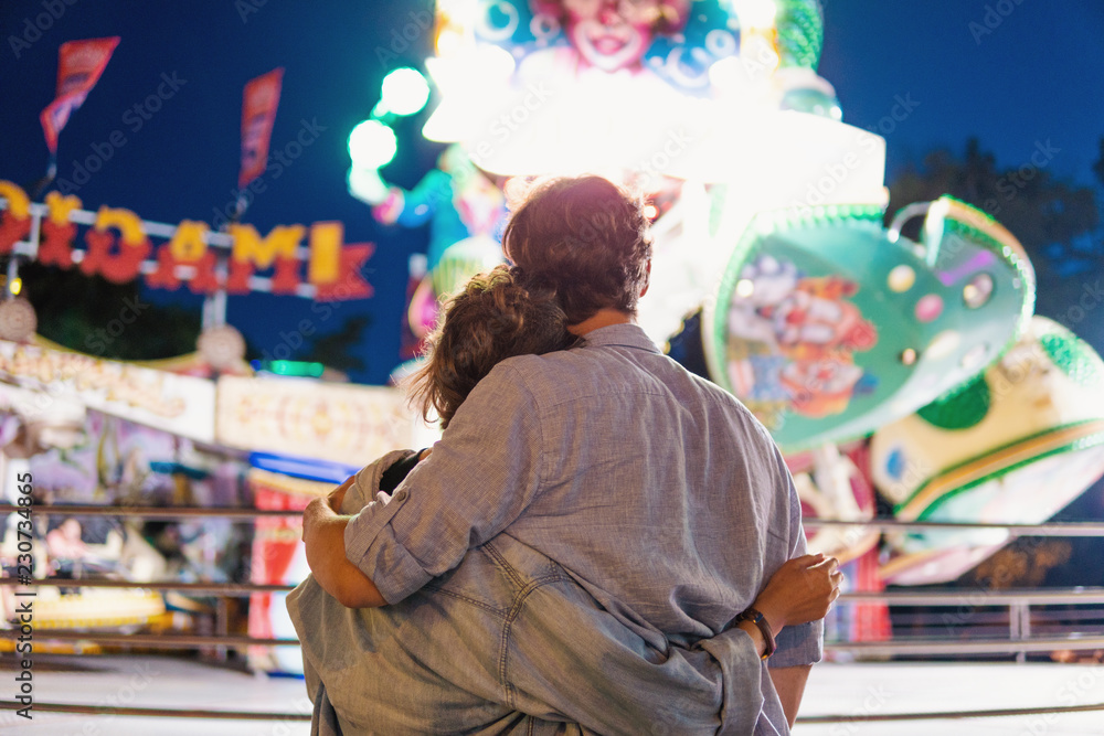 Lovely young hipster couple dating in amusment theme park. they wear jeans clothes. modern youth relationship. Ferris wheel on background Lovely young hipster couple dating in amusment theme park. they wear jeans clothes. modern youth relationship. Ferris wheel on background
