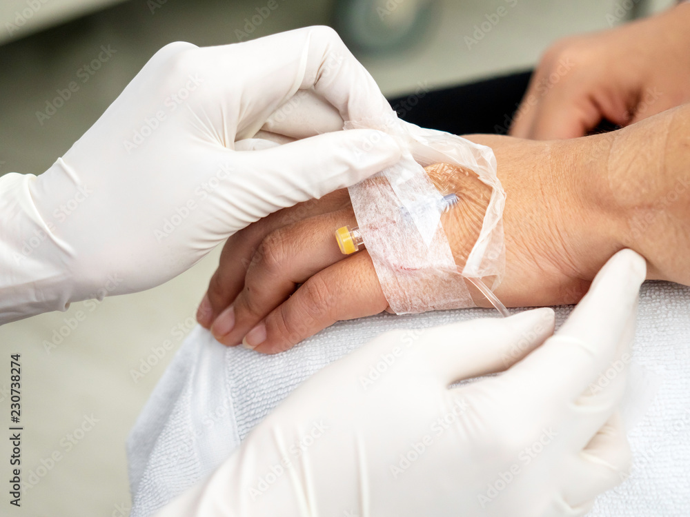 Fototapeta premium Close up hand adjust saline IV drip for patient in hospital