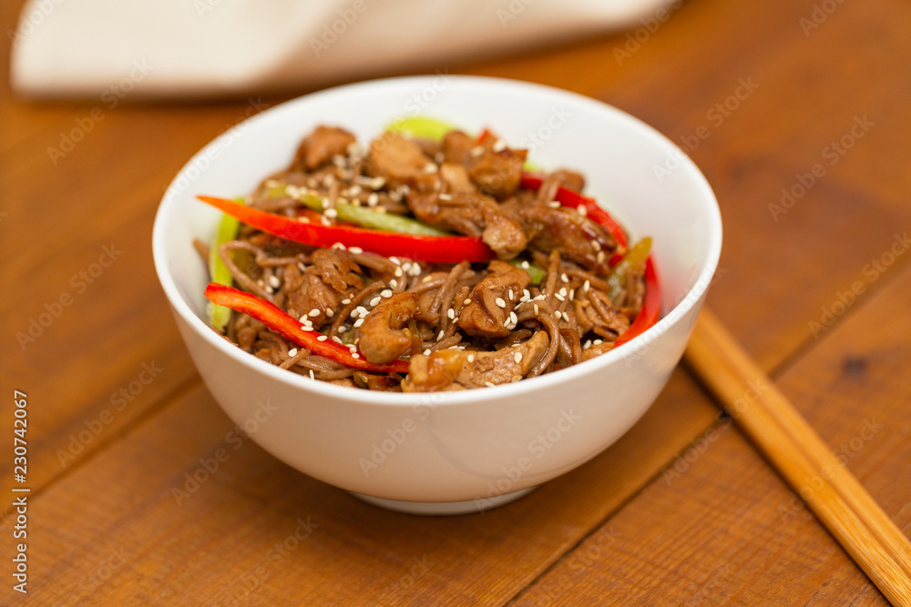 Noodles with pork, vegetables and sesame. On a wooden table. Noodles with pork, vegetables and sesame. On a wooden table.