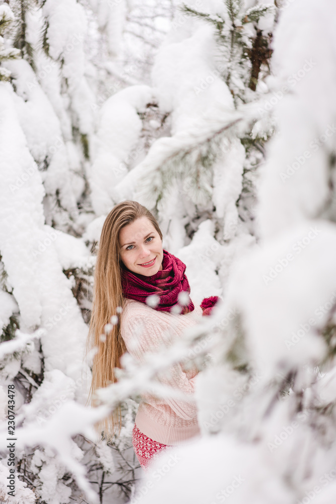 Smiling young woman outdoors in a winter forest Smiling young woman outdoors in a winter forest