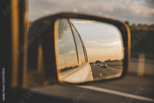 car on highway. sunset in car mirror reflection