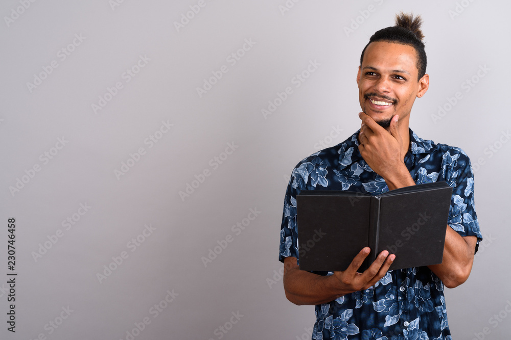 Young bearded handsome African man against gray background Young bearded handsome African man against gray background