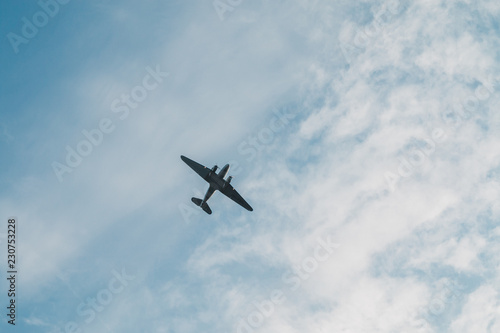 Passenger airplane flying at flight level high in the sky above cumulus clouds and blue sky. 