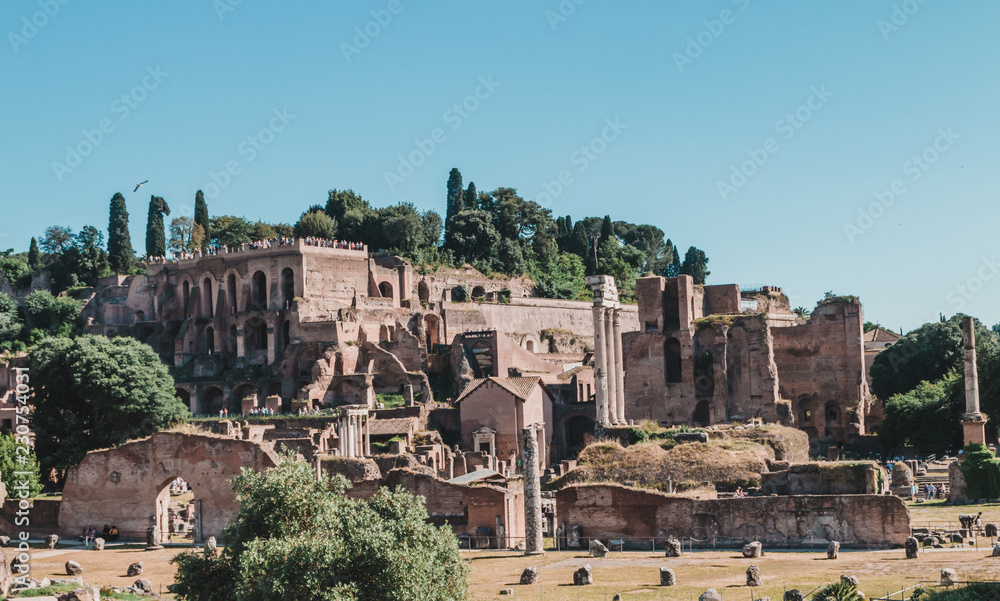 View of Roman Forum with the Temple of Saturn, Rome, Italy. Roman Forum is one of the main travel destinations in Europe. Beautiful panorama of Roman Forum in summer. Ancient ruins in central Roma.