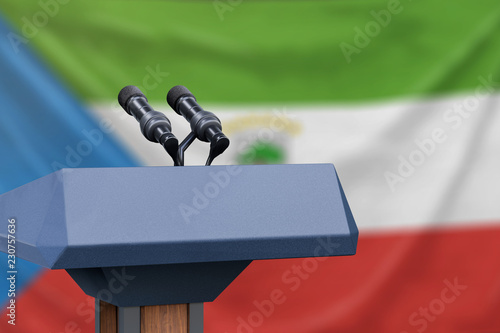 Podium lectern with two microphones and Equatorial Guinea flag in background