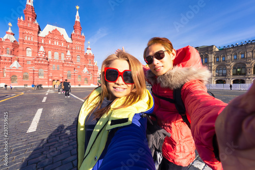 Happy tourists visiting State Historical Museum on Red Square in Moscow, Russia ,which successful traveling couple in love taking a selfie on phone