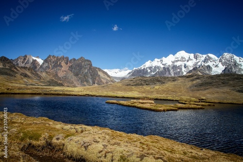 Panoramic view of the lake in spectacular high mountains, Cordillera, Andes, Peru, with colorfull dark blue water, in the cordillera blanca, mountains covered by snow in background