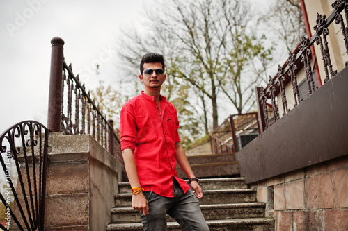 Indian man at red shirt and sunglasses posed outdoor. © AS Photo Family
