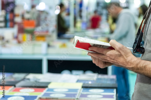 Man reading a book at the stand in a book fair