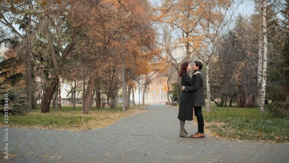 Lovely young couple meeting outdoors in the autumn city park. Lovely young couple meeting outdoors in the autumn city park.