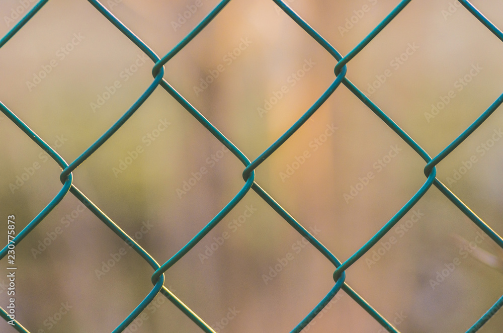 Diamond-shaped steel mesh fence close-up background Diamond-shaped steel mesh fence close-up background