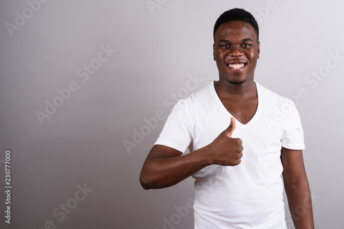 Portrait of young African man against white background