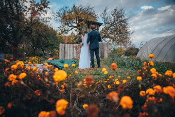 Bride and groom rural yard yellow flowers