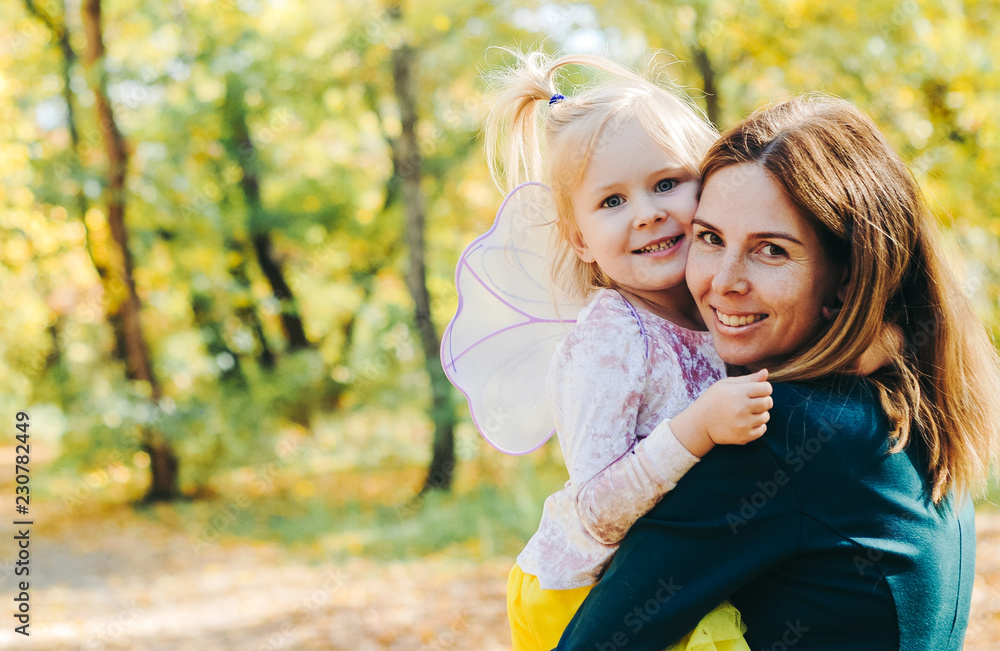 Mother and little daughter playing together in a park Mother and little daughter playing together in a park
