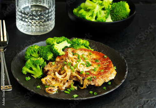 Fried pork steak with broccoli and onion sauce.