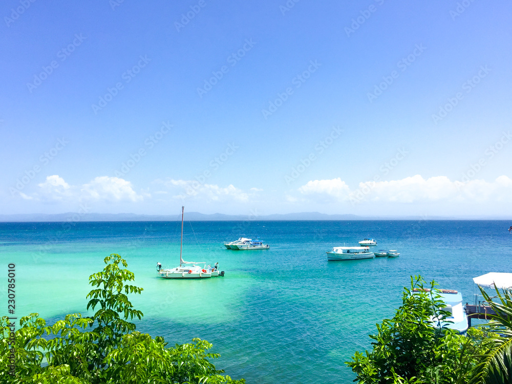 Fototapeta premium Caribbean sea with turquoise water, some boats and blue sky and 