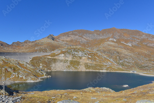 Laghetto alpino a ridotto di una diga in alta montagna nel mese di ottobre