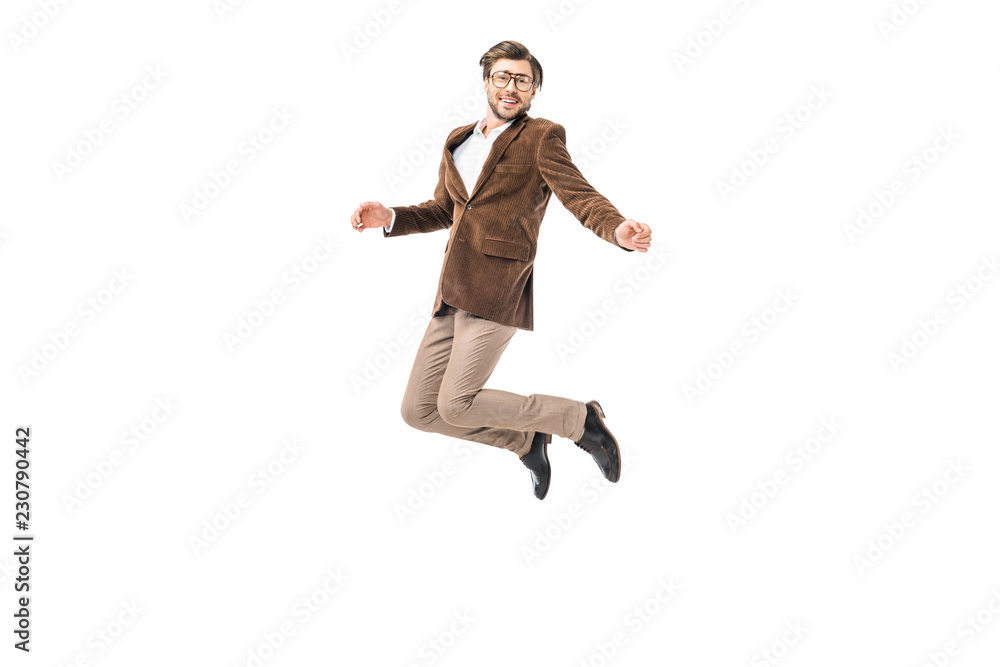 happy male model in eyeglasses and velvet jacket jumping isolated on white
