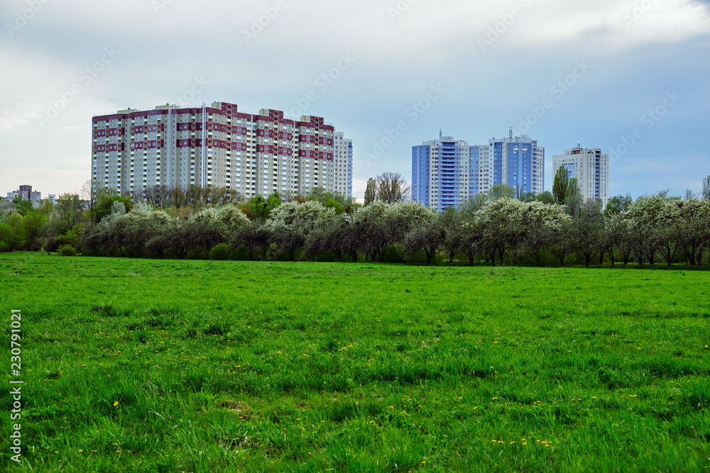 Large modern residential building and green field
