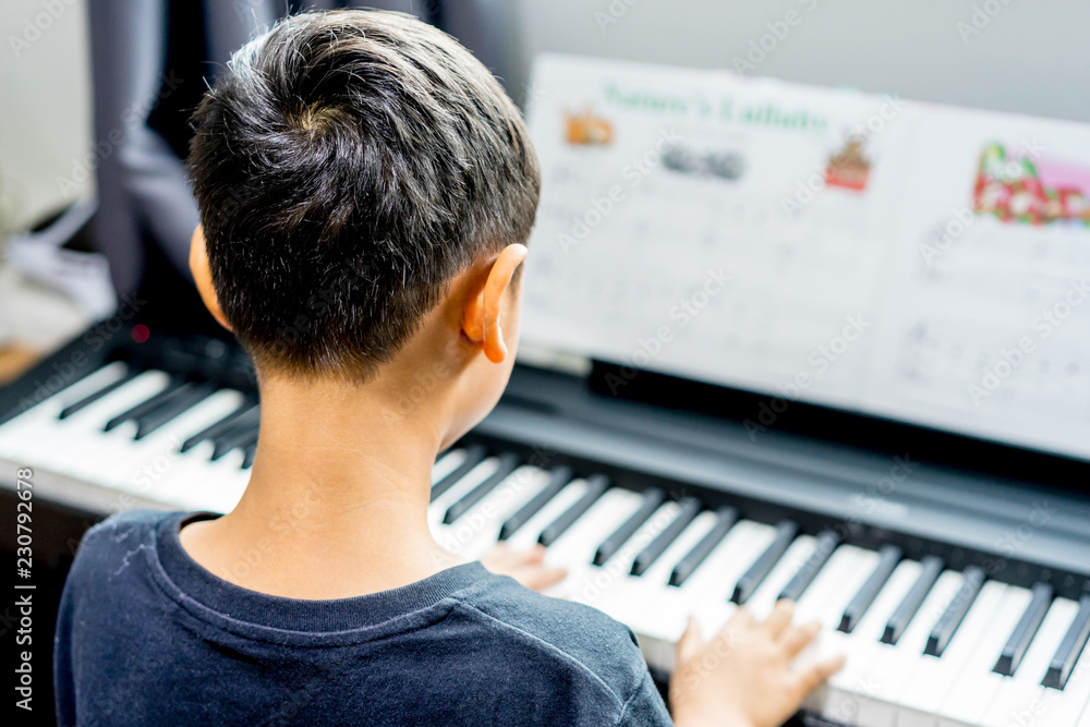 asian kid boy playing the piano in the room Stock Photo | Adobe Stock