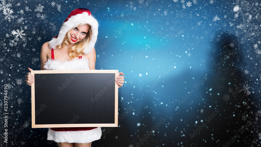 attractive miss santa with an empty blackboard in a snowy landscape attractive miss santa with an empty blackboard in a snowy landscape