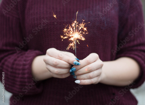 Girl hold in her hands Christmas sparkler