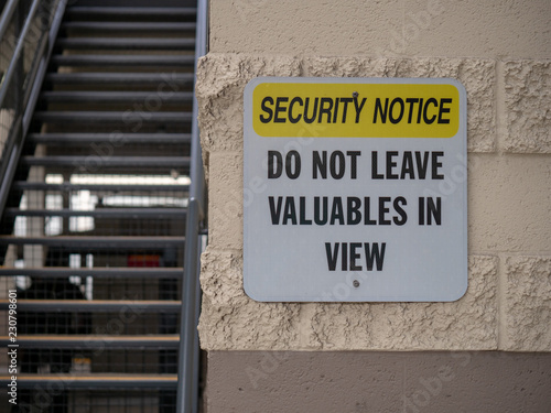 Security notice do not leave valuables in view street sign near parking lot