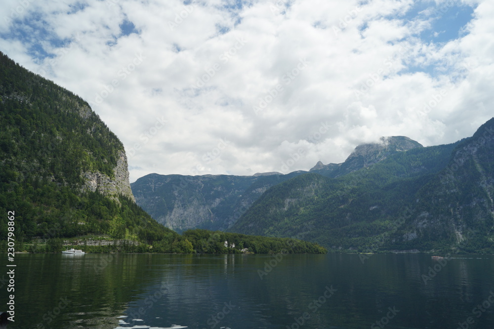 the water surface of the lake against the Alpine mountains in cloudy summer