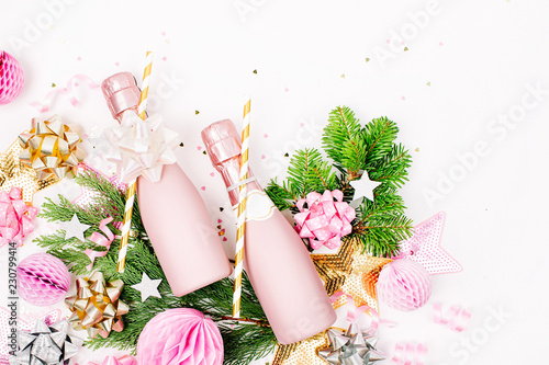 Pastel Pink confetti, champagne bottles and decorations. Flat lay, top view. Holiday composition for  New year or Christmas celebration. Flat lay, top view