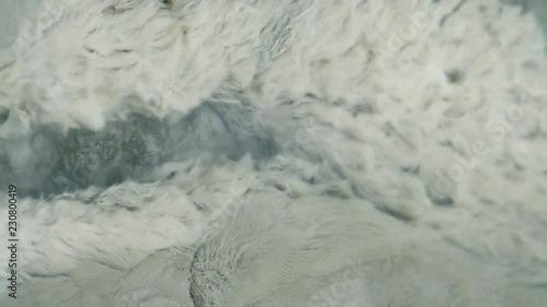 Underwater plant life, in a geothermal stream, being tossed around by the moving water. Rotorua, New Zealand.