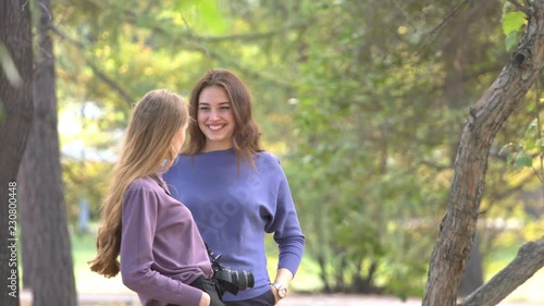 Girls in park.
Sexy looking girls are chatting to each other very actively and enjoing themselfs. They laugh and smile. On the background are trees. Positive mood. photo