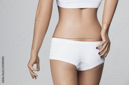 The female mannequin in white underwear over gray studio background. The woman body, fit figure, fitness, diet, sports, plastic surgery and healthy lifestyle concept. © master1305