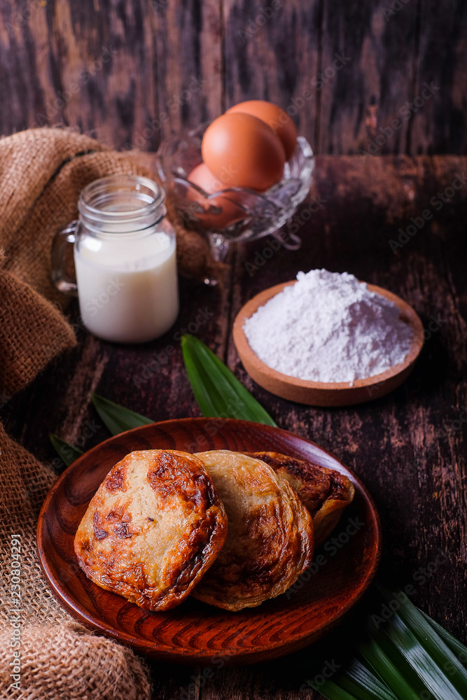 Akok Kedut, egg, coconut, flour , coconut milk and Pandan leaf on wooden background. Akok Kedut is a traditional dish in Malaysia especially East Coast.