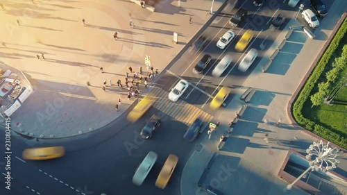 Motion timelapse of a busy Moscow crossroad on the evening, view from above. Aerial hyperlapse of urban scene of hard traffic moving and waiting at traffic lights and pedestrians crossing the road.  photo