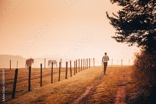 Fototapeta Naklejka Na Ścianę i Meble -  Runner in orange autumn morning nature