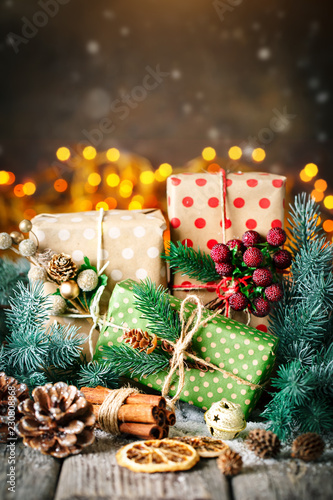 Merry Christmas and happy New year. Christmas gift and Christmas tree on dark wooden background. Selective focus.