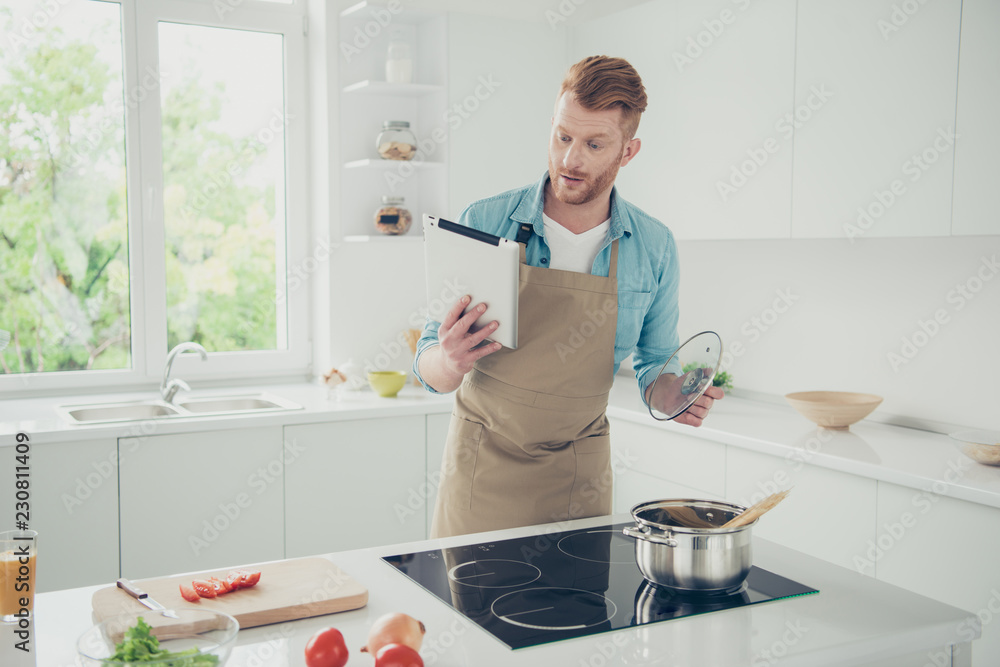 Good-looking man try figure new menu hold tablet gadget in hand Good-looking man try figure new menu hold tablet gadget in hand