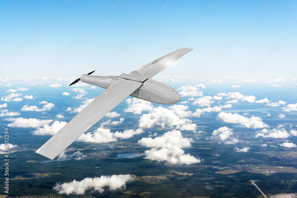 Fototapeta premium Patrolling unmanned aircraft in the sky above the terrain, fly tracking.