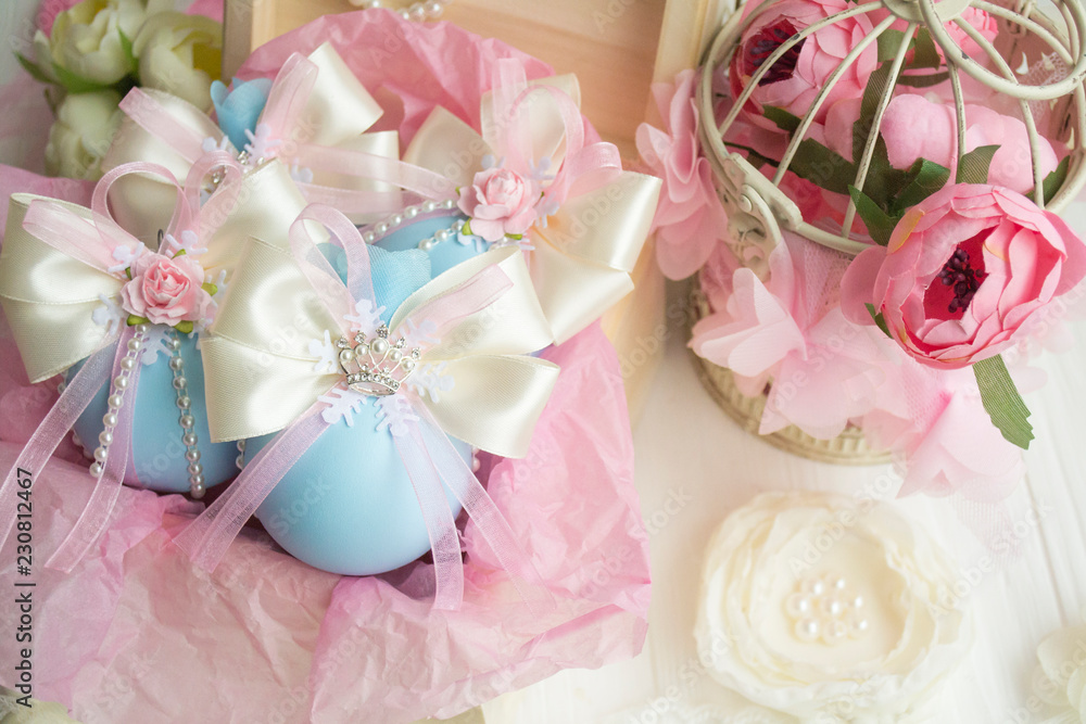 winter vacation. New Year's toys made by hand. a set of Christmas balls of blue color with a bow of satin ribbon, lace, flowers lies in a box with pink paper. winter vacation. New Year's toys made by hand. a set of Christmas balls of blue color with a bow of satin ribbon, lace, flowers lies in a box with pink paper.