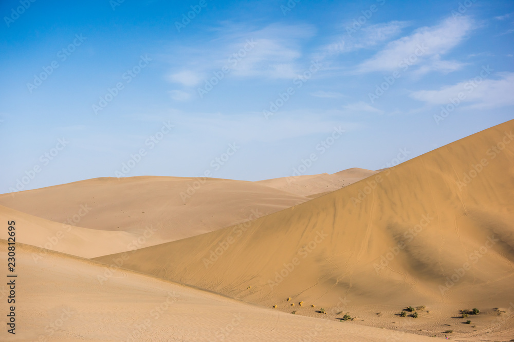 Desert sand dunes with blue sky background