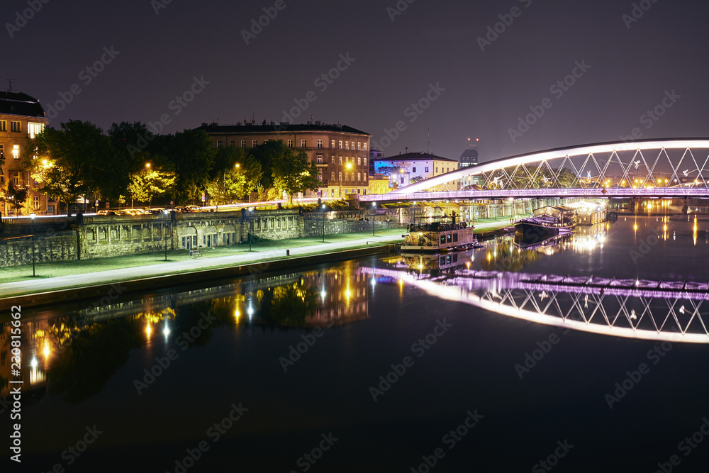pedestrian bridge over the river in Krakow at night