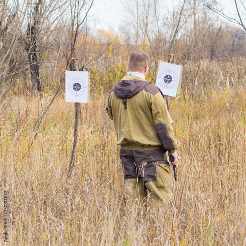 a man with a gun checks shots on target