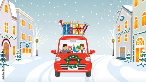 Family riding the red Car which loaded a lot of Christmas gifts in the winter town - Anonymity